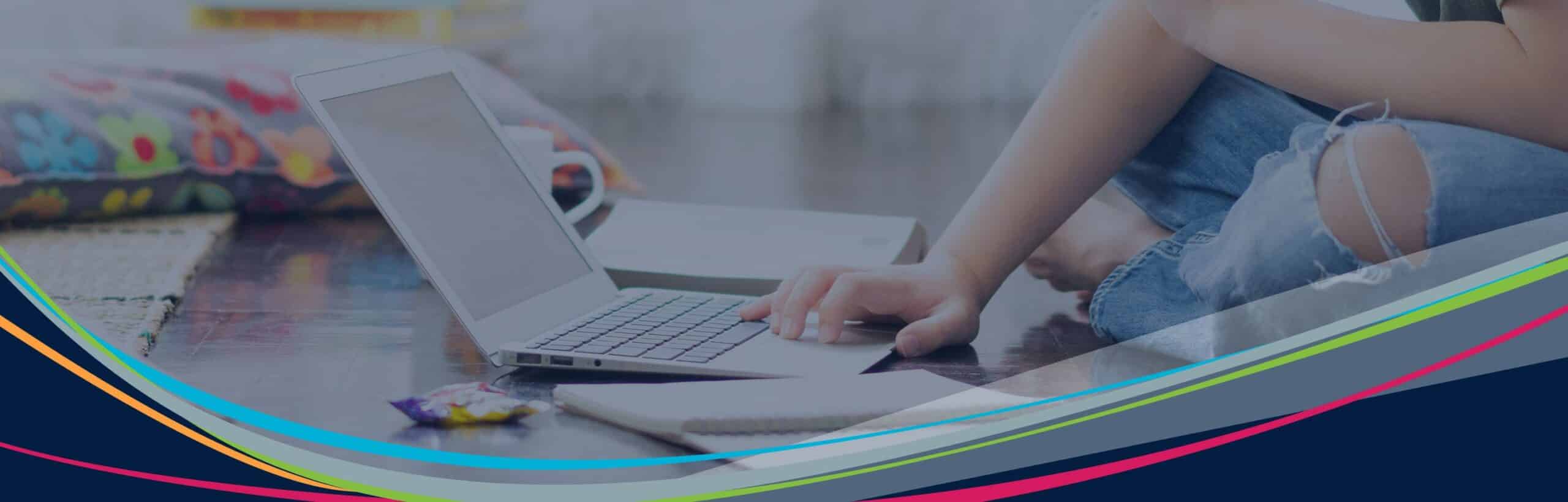 Image of student sitting on floor using laptop